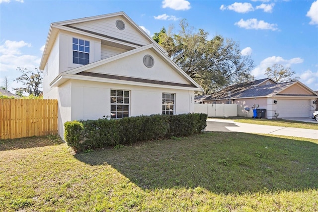 traditional-style home with fence, a front lawn, and stucco siding