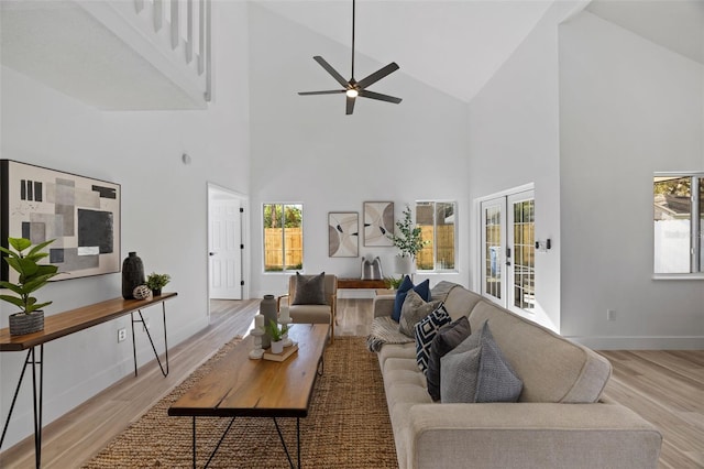 living room with french doors, lofted ceiling, ceiling fan, light wood-type flooring, and baseboards