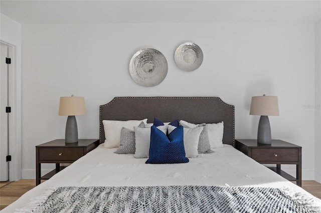 bedroom with wood finished floors and baseboards