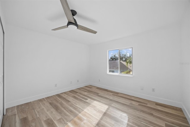 empty room with light wood-type flooring, a ceiling fan, and baseboards