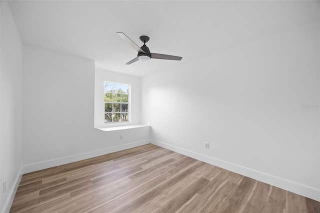 spare room with light wood-style floors, baseboards, and a ceiling fan