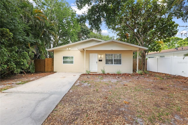 view of front of house featuring concrete block siding and fence