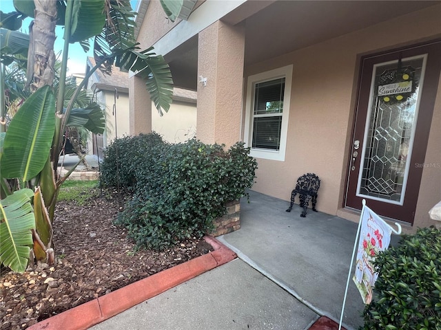 doorway to property featuring stucco siding