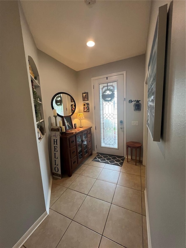 entryway featuring light tile patterned flooring, built in features, and baseboards