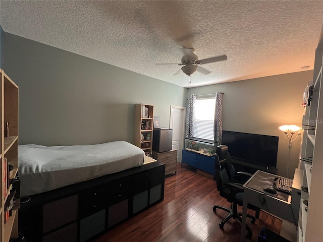 bedroom with a textured ceiling, a ceiling fan, and dark wood-type flooring