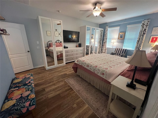 bedroom with dark wood-style floors, ceiling fan, and baseboards