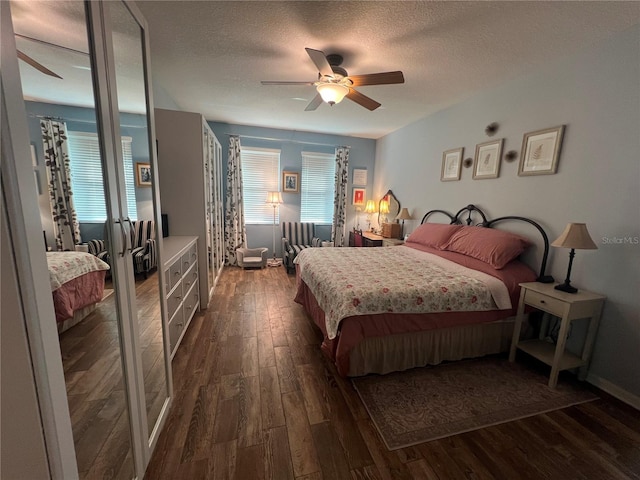 bedroom featuring ceiling fan, a textured ceiling, and dark wood-type flooring