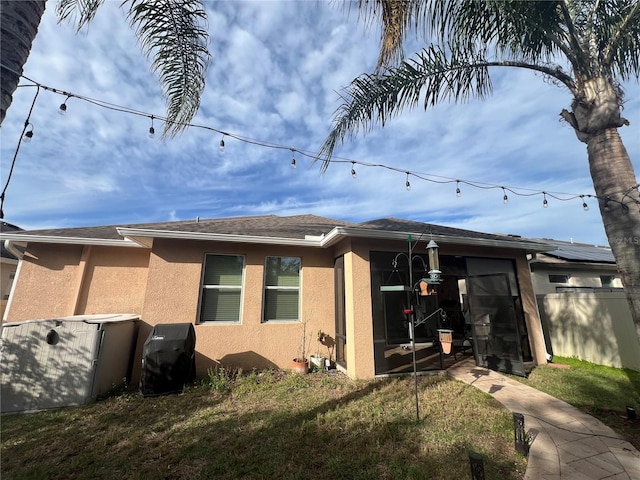 view of home's exterior with fence, a lawn, and stucco siding