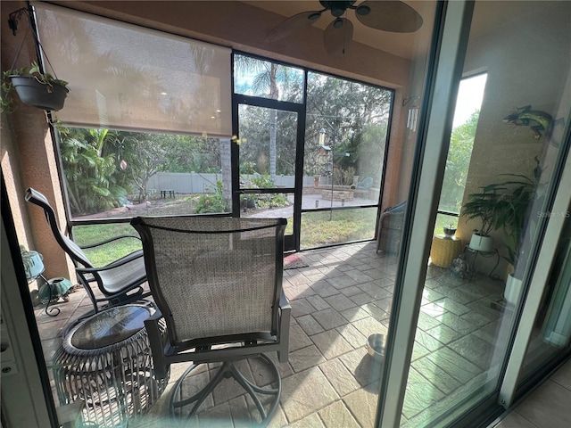 sunroom / solarium featuring a ceiling fan