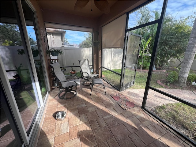 sunroom / solarium featuring a ceiling fan