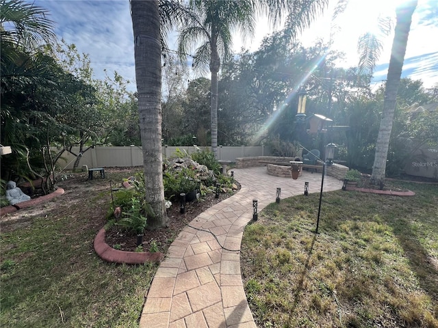 view of yard with a fire pit, a patio, and a fenced backyard