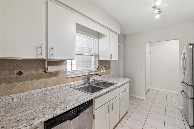 kitchen featuring light tile patterned flooring, stainless steel appliances, a sink, baseboards, and decorative backsplash