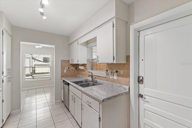 kitchen featuring a wealth of natural light, light countertops, a sink, and decorative backsplash