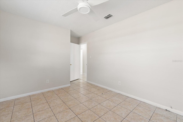 unfurnished room with light tile patterned floors, visible vents, ceiling fan, a textured ceiling, and baseboards