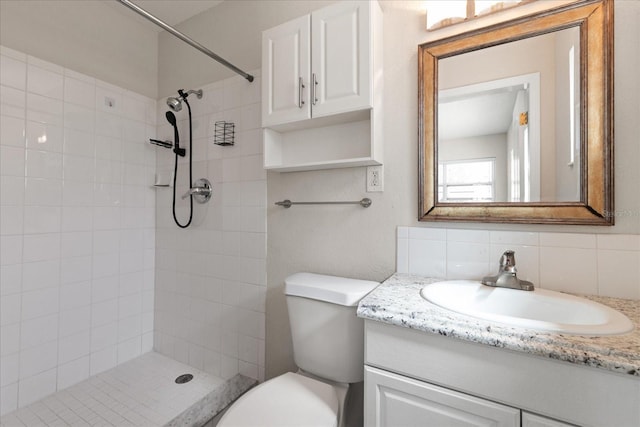 full bath featuring tasteful backsplash, tiled shower, vanity, and toilet