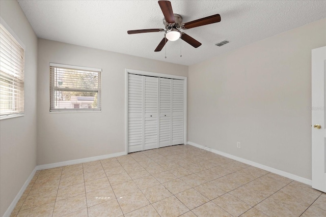 unfurnished bedroom with baseboards, a closet, visible vents, and a textured ceiling