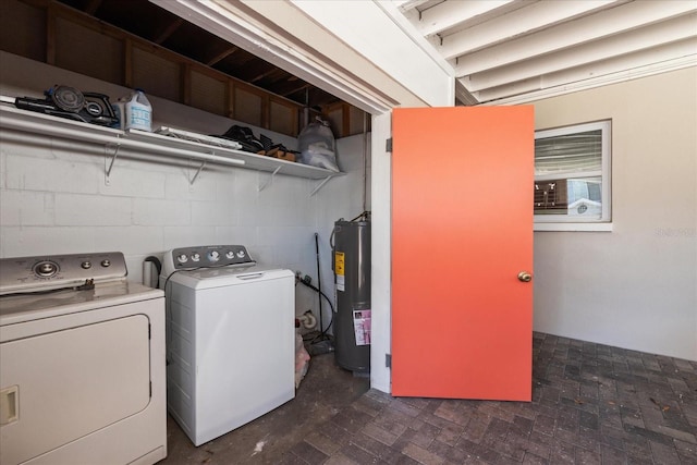 laundry area with concrete block wall, laundry area, washing machine and dryer, and electric water heater