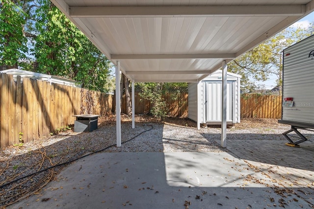 view of patio / terrace featuring an outbuilding, a fenced backyard, and a storage shed