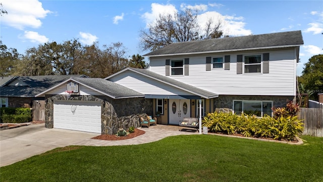 view of front of property with a garage, fence, stone siding, driveway, and a front lawn