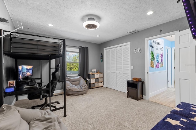 bedroom with baseboards, carpet, visible vents, and a textured ceiling