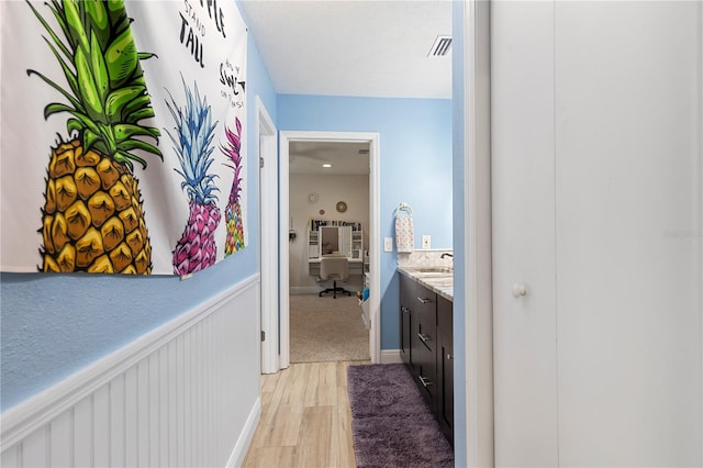 bathroom featuring wainscoting, visible vents, vanity, and wood finished floors