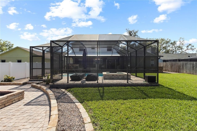 rear view of property featuring a patio, a lawn, a fenced backyard, and a fenced in pool