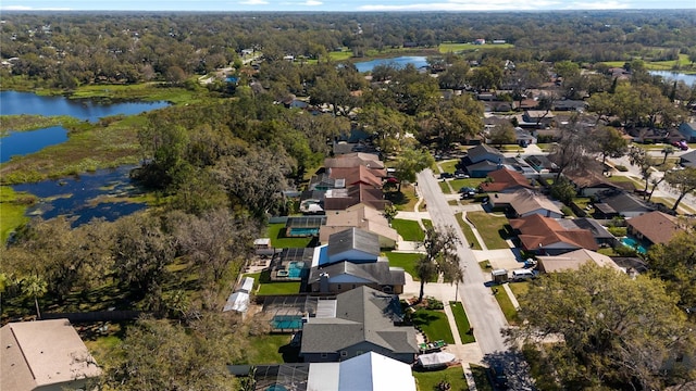 aerial view with a forest view, a water view, and a residential view