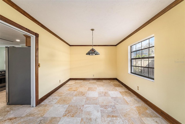 empty room featuring ornamental molding, stone finish flooring, a textured ceiling, and baseboards