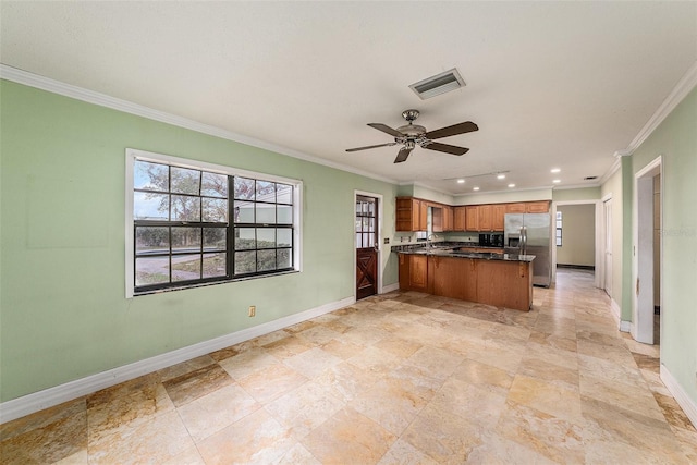 kitchen featuring brown cabinets, stainless steel refrigerator with ice dispenser, visible vents, a peninsula, and baseboards