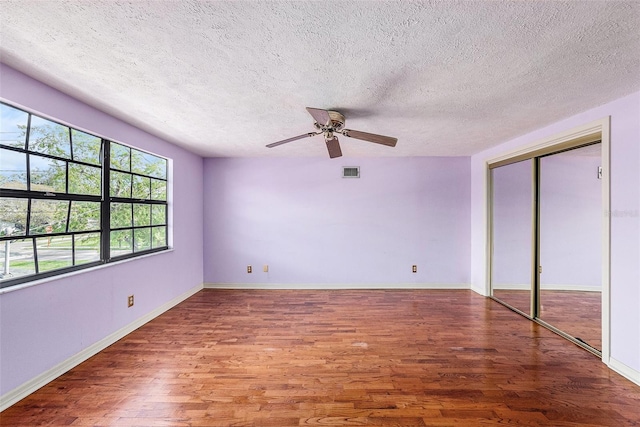 unfurnished bedroom featuring baseboards, visible vents, and wood finished floors