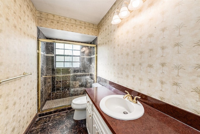 bathroom with toilet, a shower stall, vanity, and wallpapered walls