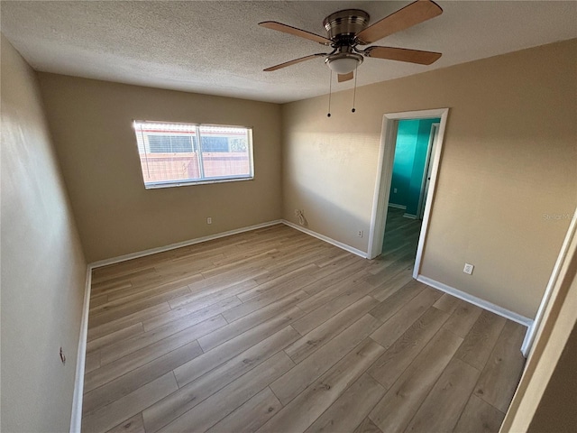 empty room featuring baseboards, a textured ceiling, a ceiling fan, and wood finished floors