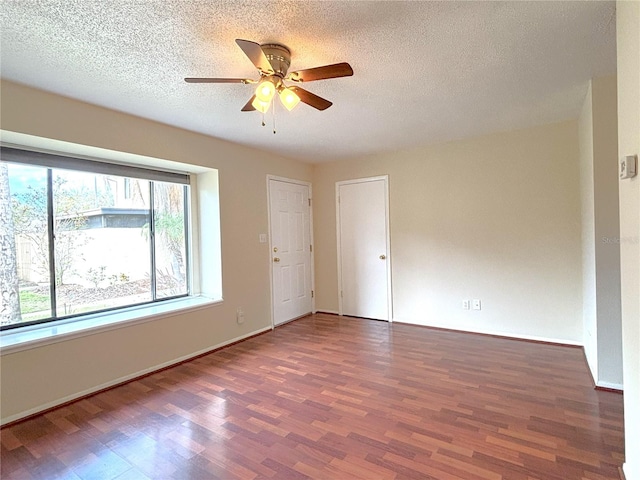 spare room featuring ceiling fan, baseboards, a textured ceiling, and wood finished floors