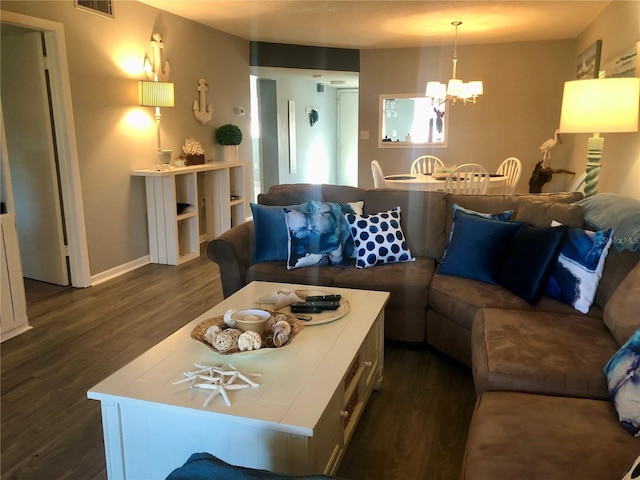 living area with dark wood-style floors, visible vents, a chandelier, and baseboards