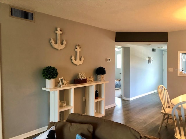 living room featuring baseboards, visible vents, and wood finished floors