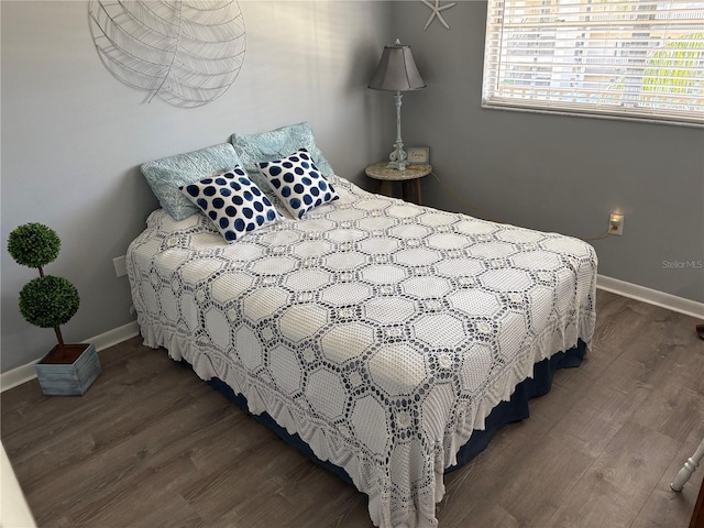 bedroom featuring baseboards and dark wood finished floors