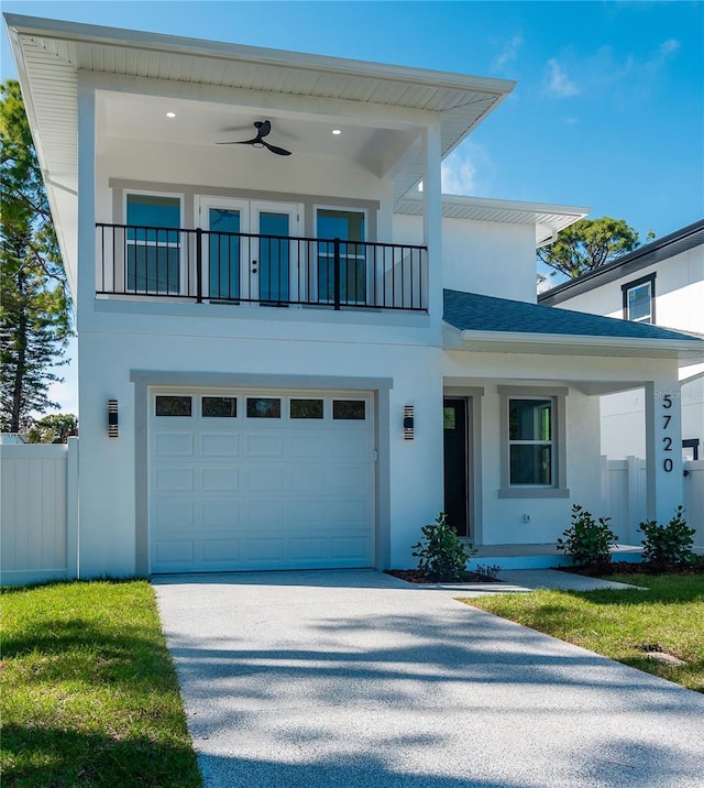 view of front of property with a balcony, driveway, fence, and stucco siding