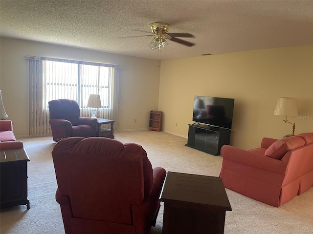 living room featuring a ceiling fan, light carpet, a textured ceiling, and baseboards