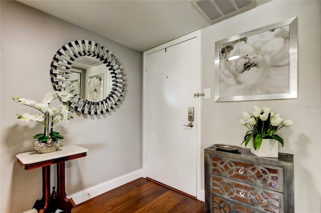 entryway with dark wood-style floors, visible vents, and baseboards