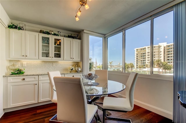 dining space with dark wood finished floors and baseboards