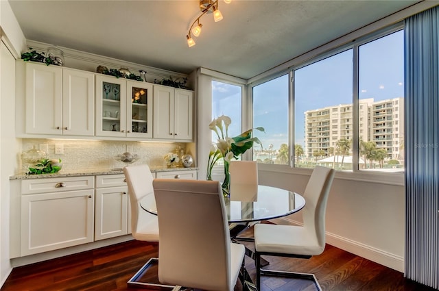 dining space featuring dark wood-style floors and baseboards