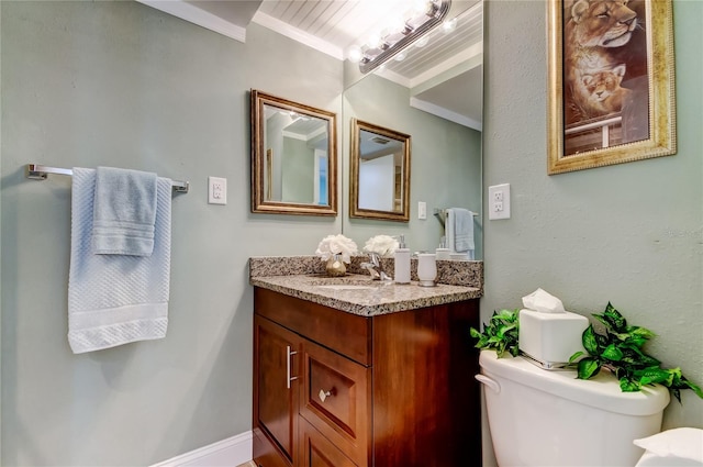 half bathroom with toilet, baseboards, vanity, and crown molding