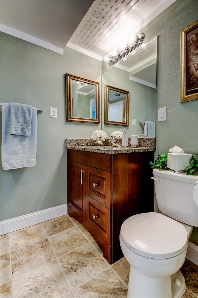 half bath featuring ornamental molding, vanity, toilet, and baseboards