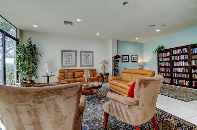 tiled living room with visible vents, a wall of windows, and recessed lighting