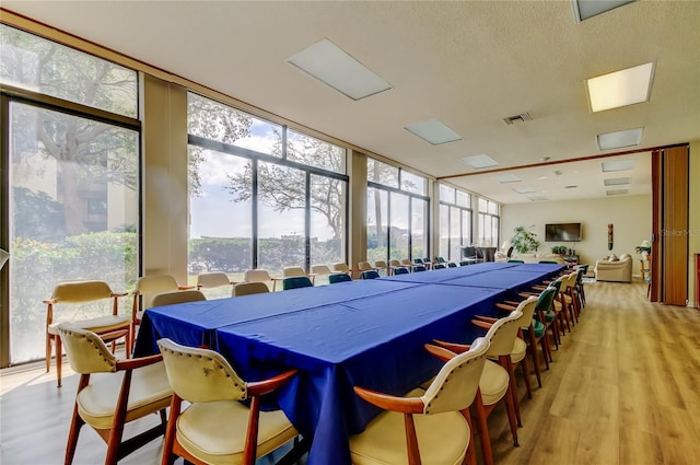 rec room featuring floor to ceiling windows, visible vents, and light wood finished floors