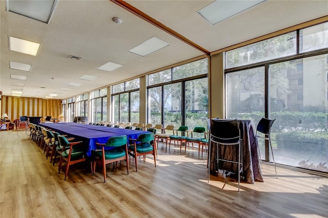 recreation room featuring expansive windows, a healthy amount of sunlight, and wood finished floors