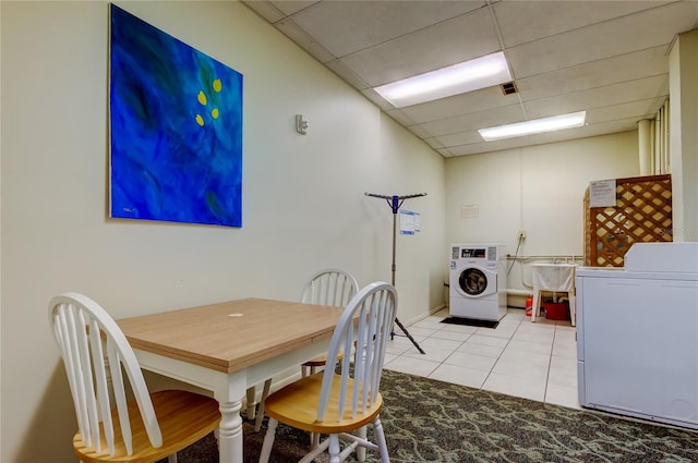 dining room featuring a paneled ceiling, light tile patterned floors, and separate washer and dryer