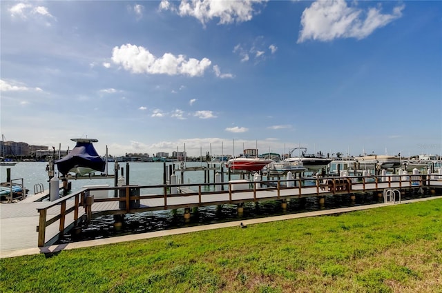 view of dock with a water view, a yard, and boat lift