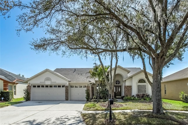 view of front of house featuring driveway, a shingled roof, an attached garage, and stucco siding