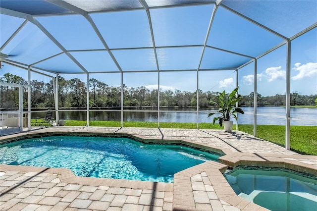 view of pool featuring a water view, a patio area, a pool with connected hot tub, and glass enclosure